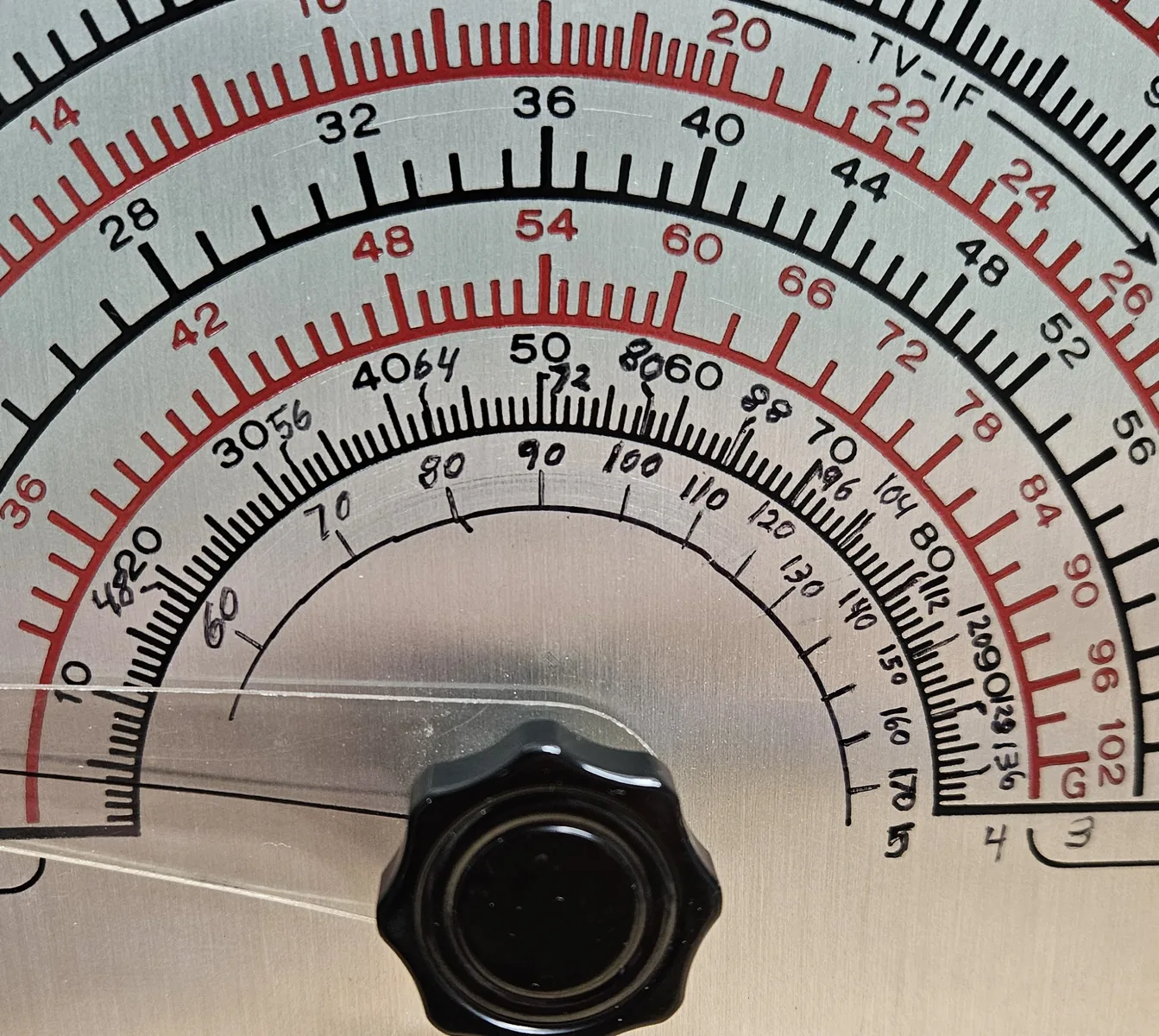 A close view of the center of the tuning dial, where extra numbers from 60 to 170 and a new scale line have been written in by hand in black ink