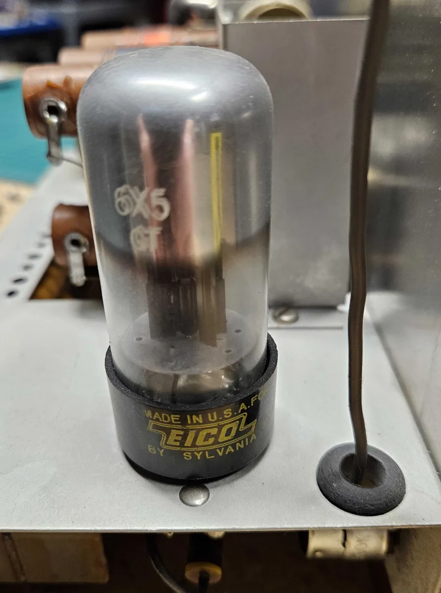 A glass vacuum tube marked 6X5 GT, with Made in U.S.A. for EICO by Sylvania printed in gold on its black base