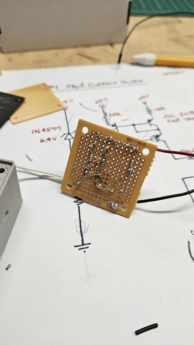 The back of the perfboard with soldered wiring, next to a hand-drawn diagram